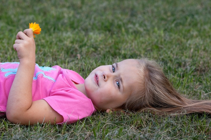 Portrait eines Mädchens liegend auf dem Rasen